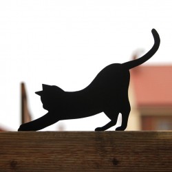 Czarny kot Mizia przykręcony do płotu